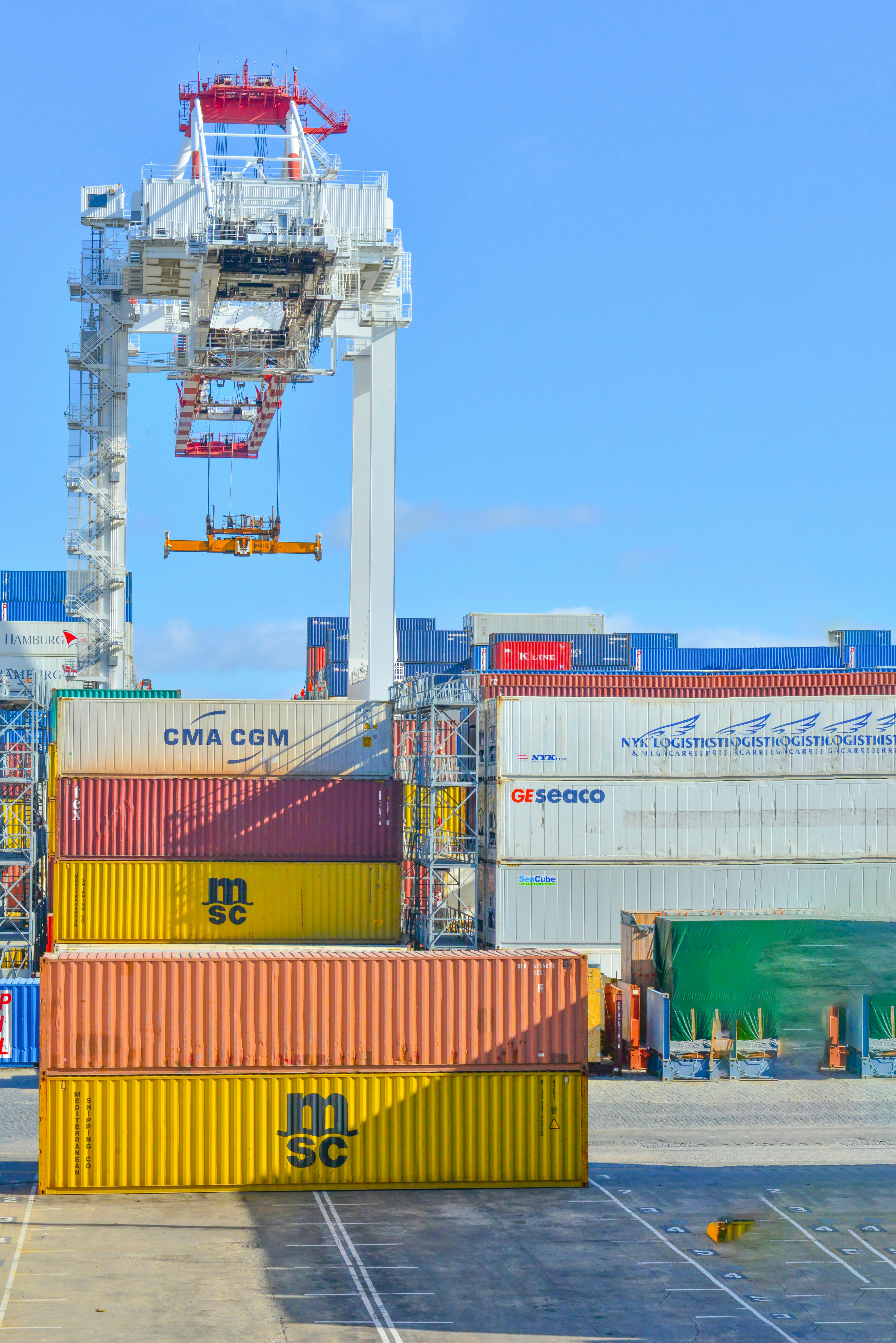 A crane at a dock offloading shipping containers